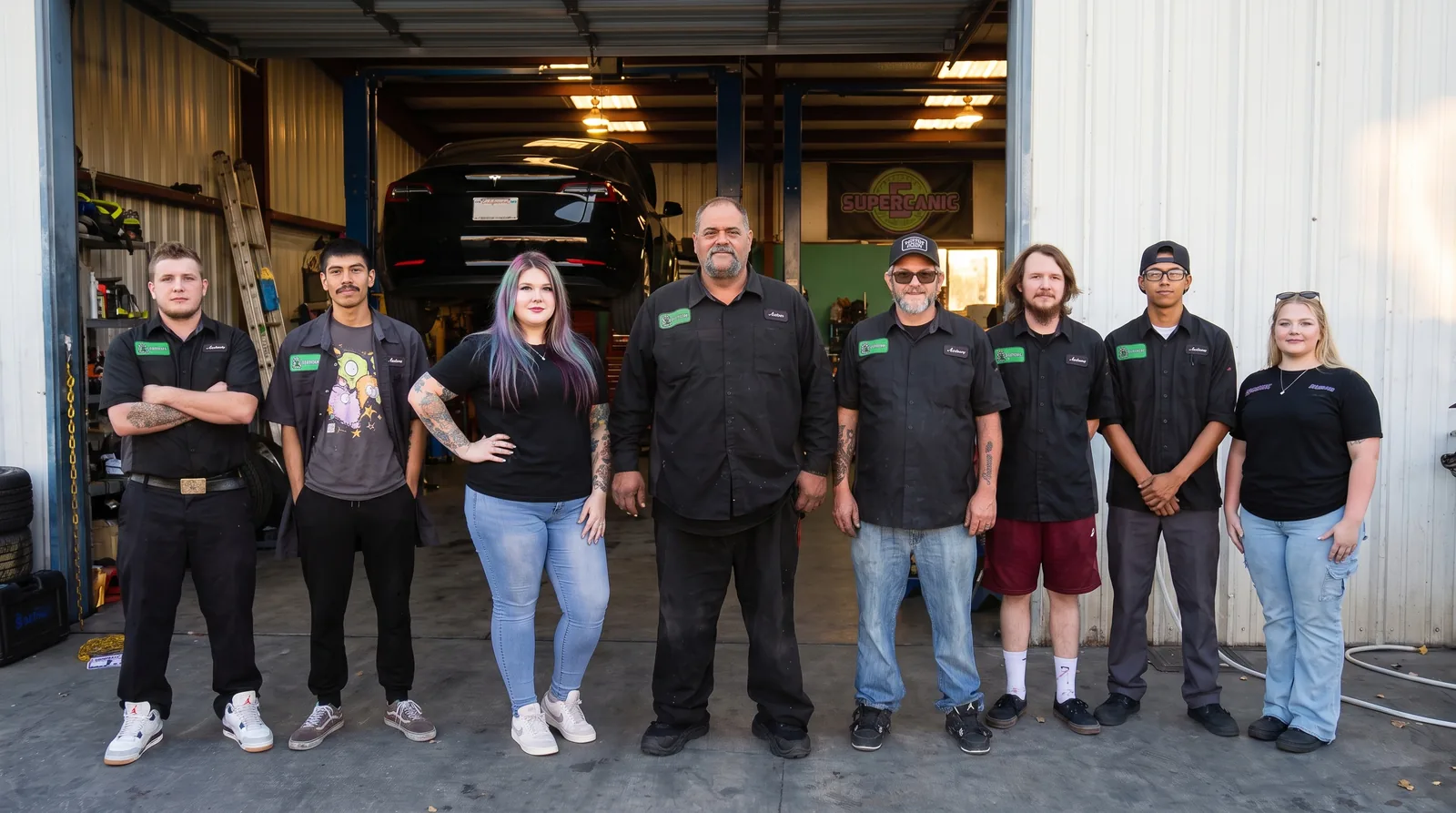 The Supercanic crew lined up in front of the open bays at the San Jacinto shop