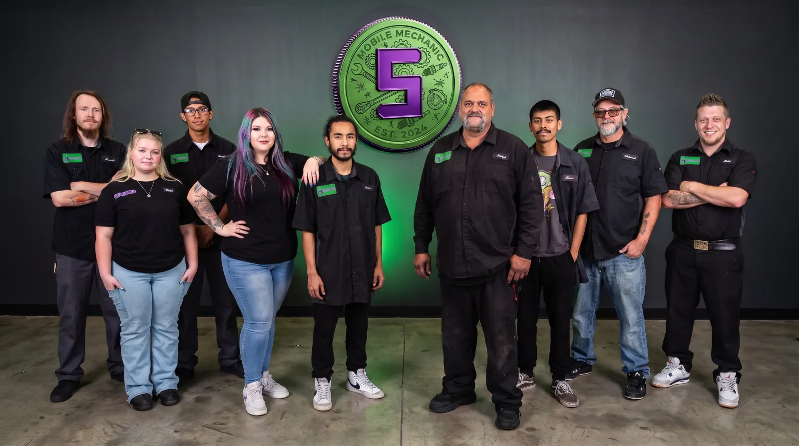 The Supercanic crew standing under the big green Supercanic coin logo