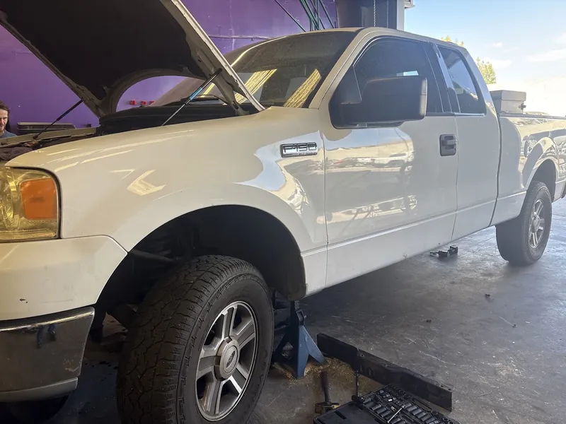 White Ford F-150 on jack stands in the Supercanic bay
