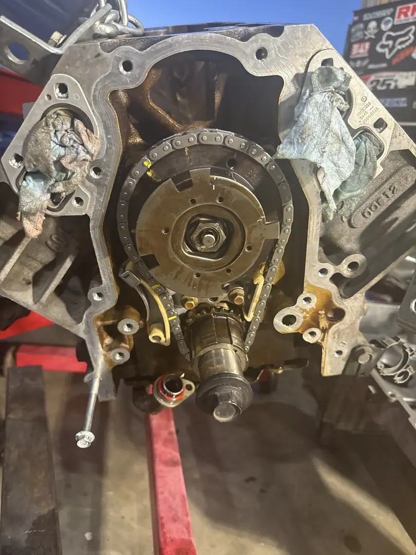 The front of a bare LS V8 block on an engine stand showing the timing gear