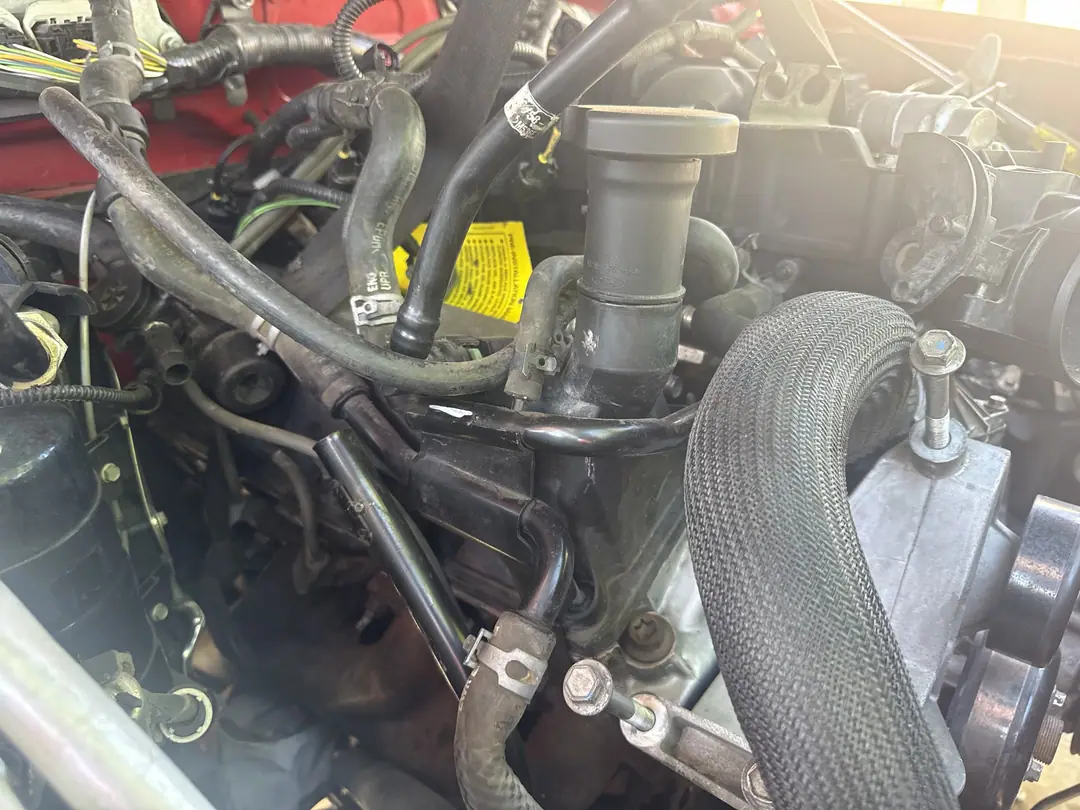 The replacement engine installed in the red Ford Ranger with hoses and wiring connected