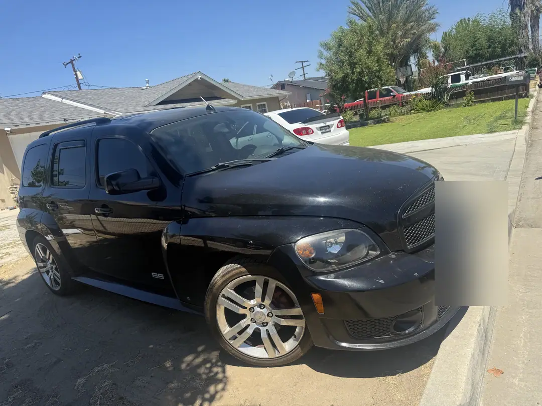 A black compact SUV parked at the curb in front of a house, July 2025