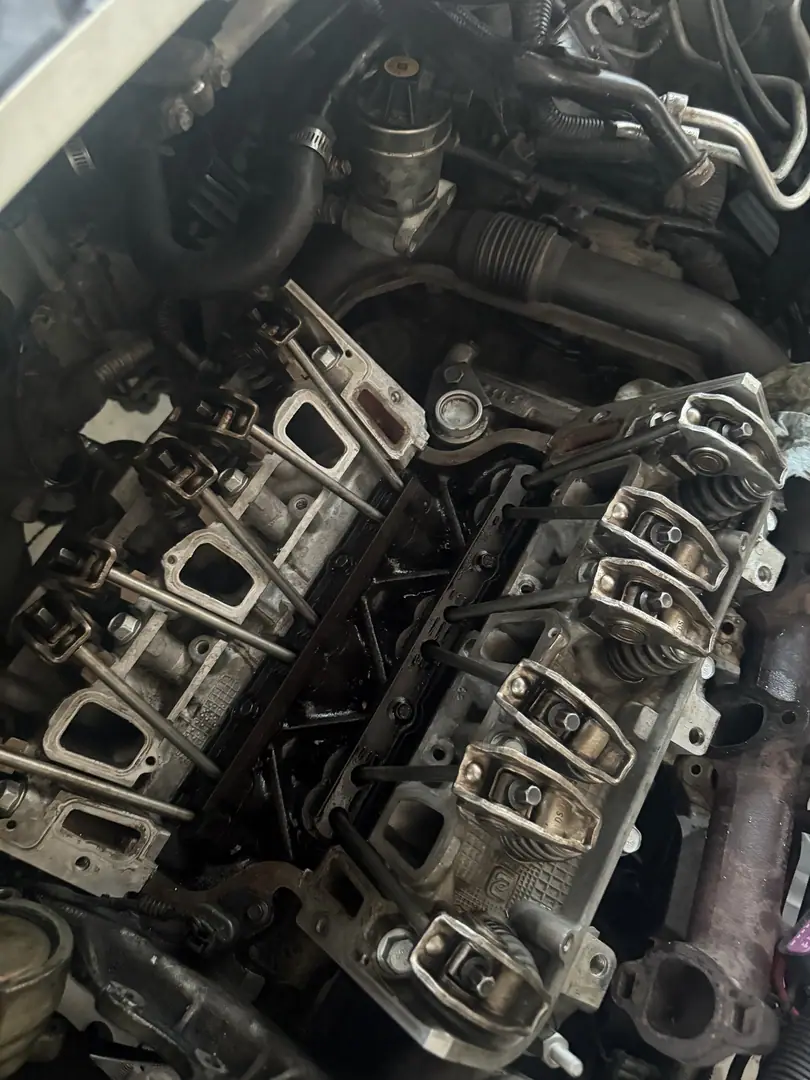 The top of a V8 with the valve covers off, showing rocker arms and pushrods, at the yard