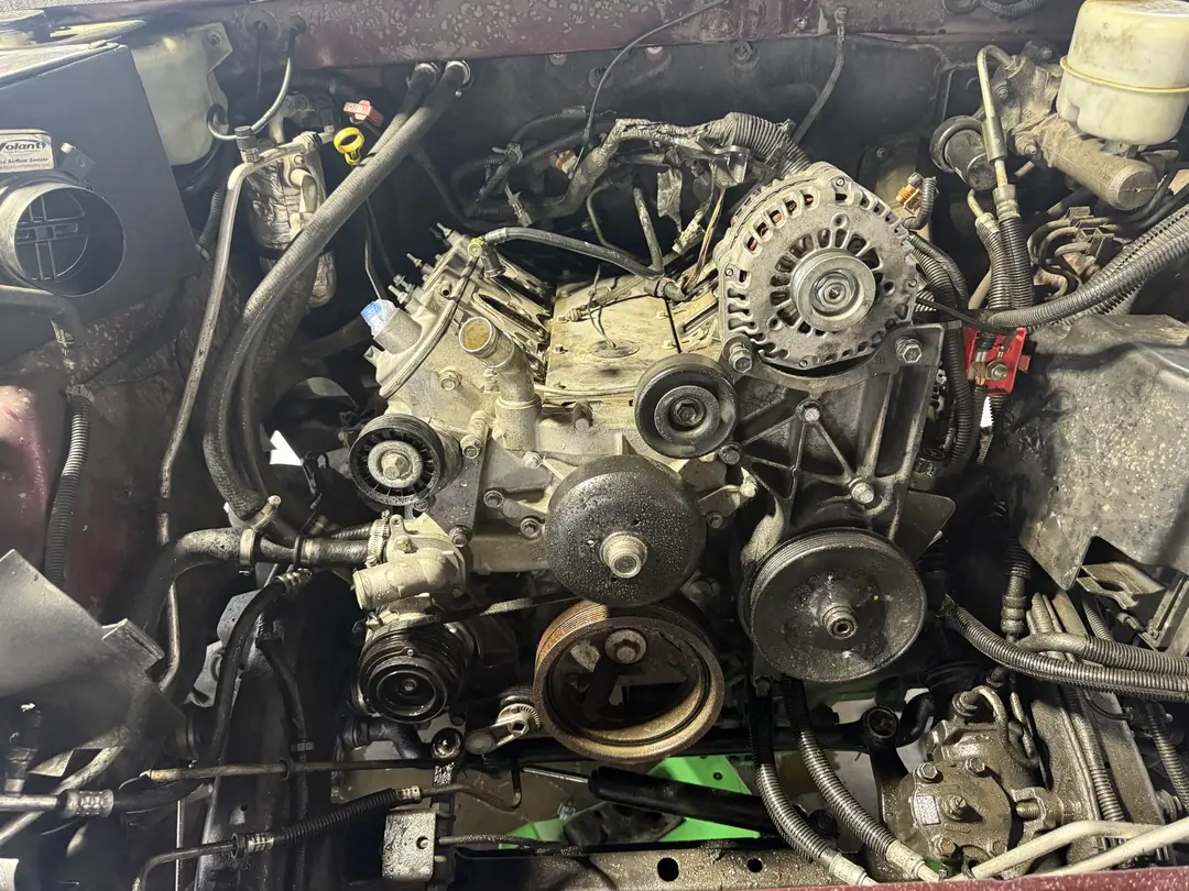 A GM V8 with the accessory drive and pulleys in place inside a truck engine bay
