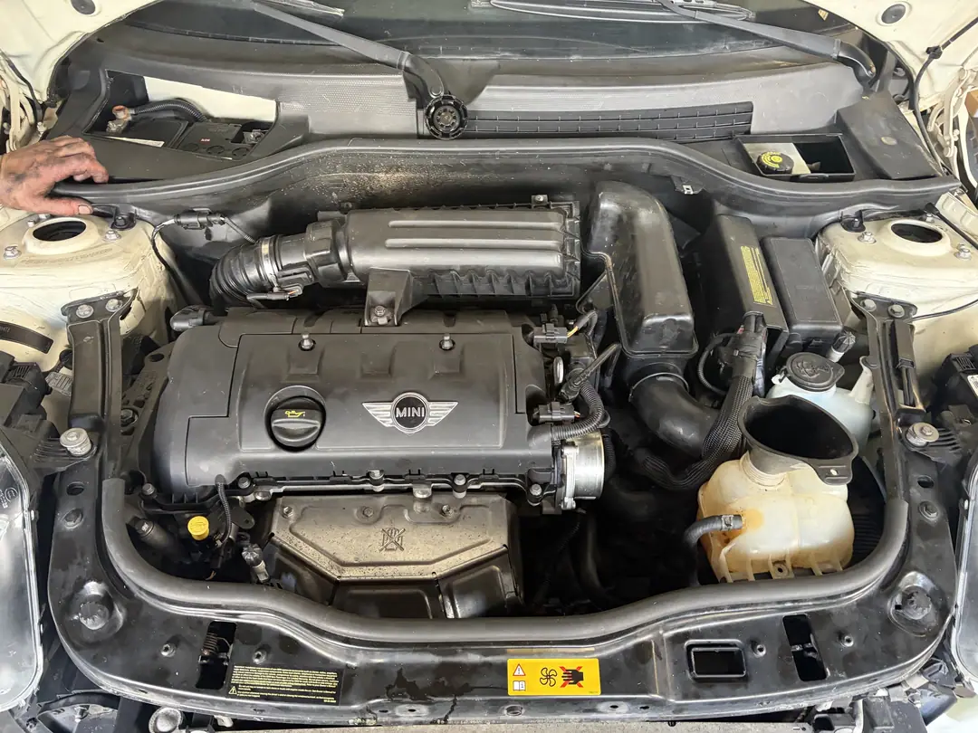 The Mini Cooper engine back in place with the intake and coolant tank installed
