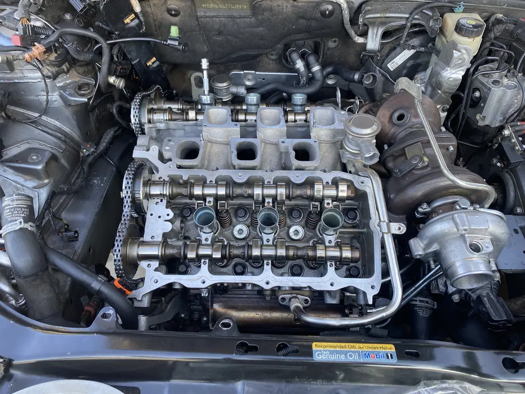 The top of a V6 engine with the valve cover off, showing camshafts, valve springs and the timing chain