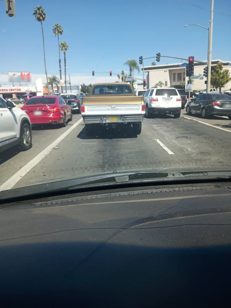 The 1976 Chevy Cheyenne seen from behind in city traffic