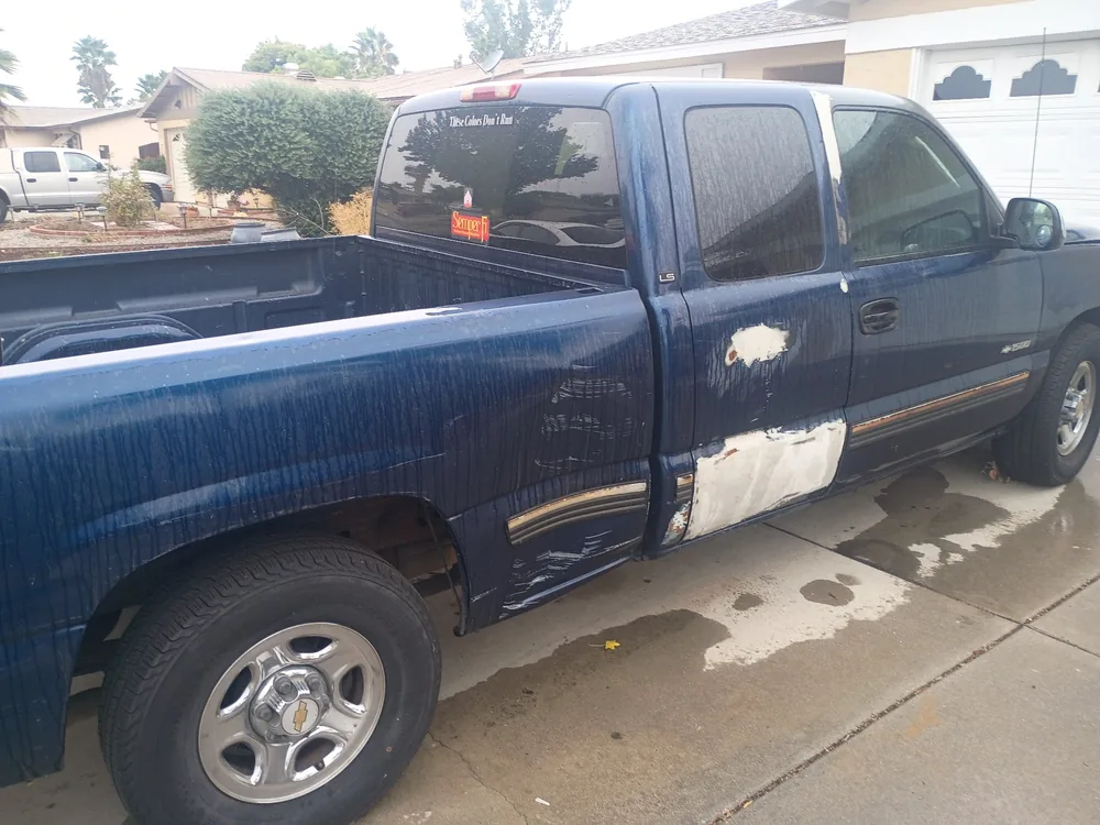 The driver side of the blue 1999 Silverado in the driveway after the fuel pump job