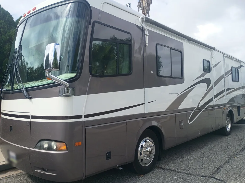 A 2001 Holiday Rambler Endeavor motorhome in tan and white parked on a street