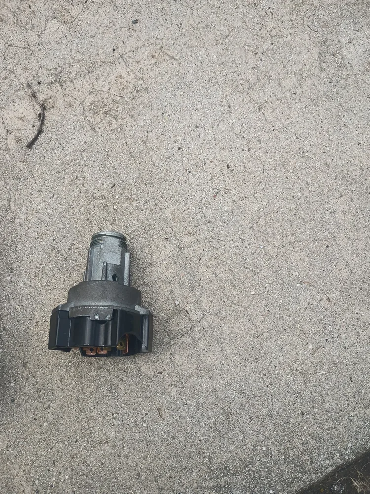 The old ignition switch from a 2001 Holiday Rambler Endeavor lying on concrete after removal