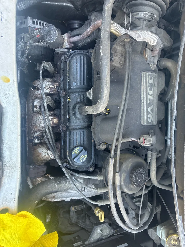 The engine bay of a 2006 Dodge Caravan showing the 3.3 liter V6, spark plug wires and intake