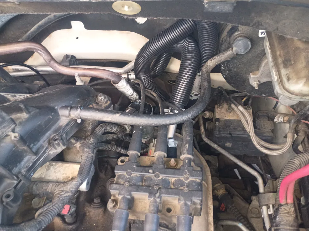 The rear of the 3.8 V6 engine bay in a 2010 Chrysler Town and Country, with the ignition coil and wiring against the firewall