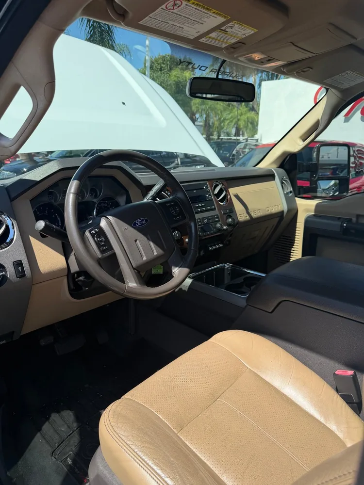 The front seats and dash of a 2011 Ford F-250 with tan leather