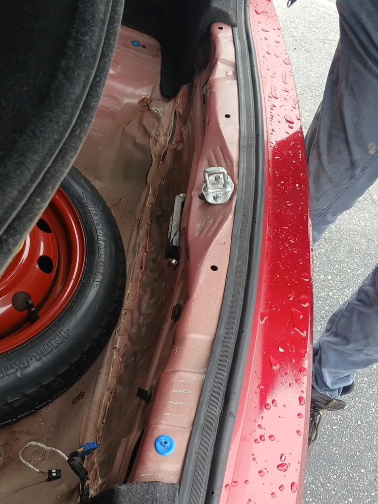 Trunk of the red 2017 Hyundai Elantra with the floor cover lifted, showing the spare tire and the rear body seam