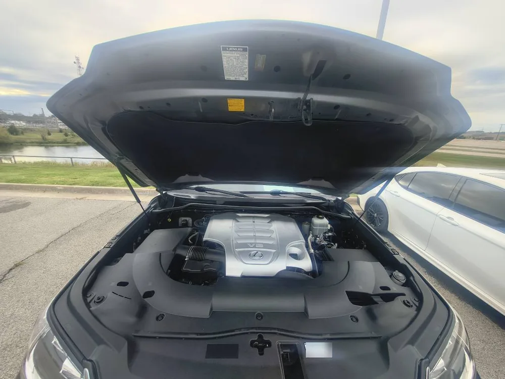 The engine bay of a 2018 Lexus LX570 with the hood up and the V8 engine cover in view