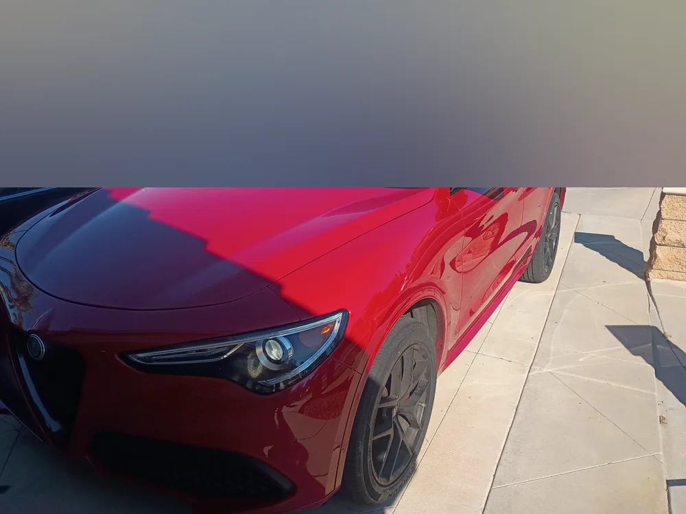 A red 2020 Alfa Romeo Stelvio parked in a driveway before its hood release repair