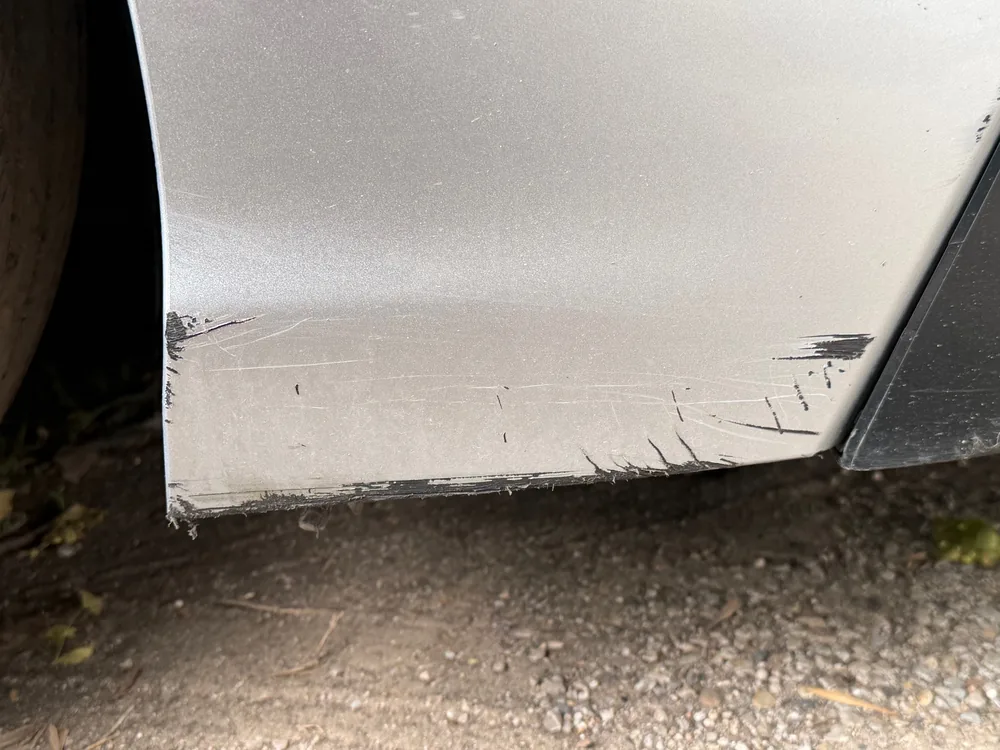 Scrapes and scratches along the lower edge of a silver 2022 Toyota Camry body panel