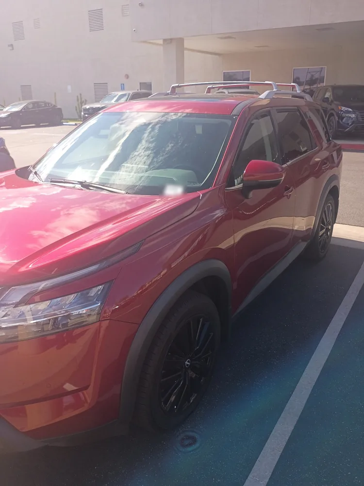 Front quarter of a red 2022 Nissan Pathfinder parked on a dealer lot in Murrieta for a pre-purchase inspection