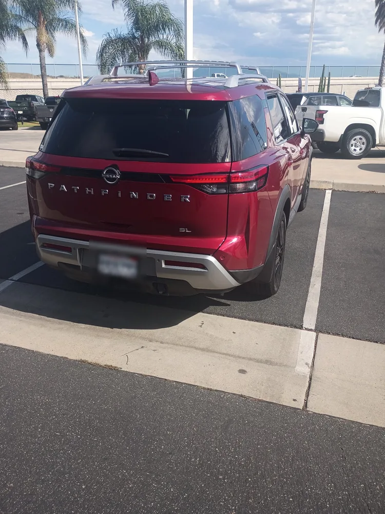 Rear of a red 2022 Nissan Pathfinder SL parked in a dealer lot space
