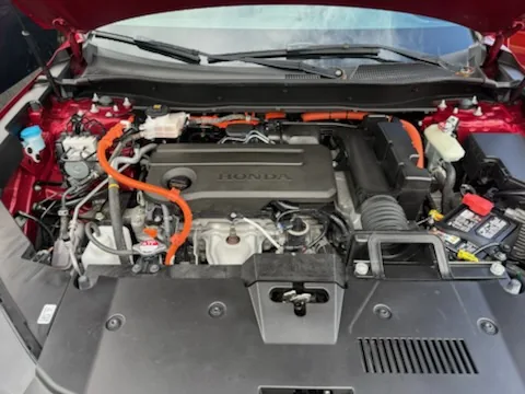 The engine bay of a 2024 Honda CR-V Hybrid with orange high voltage cables visible