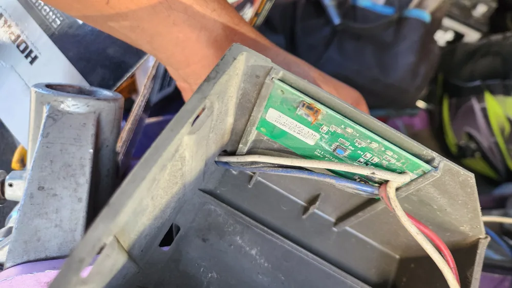 The breakaway battery box on a cargo trailer opened up to show its circuit board and wires