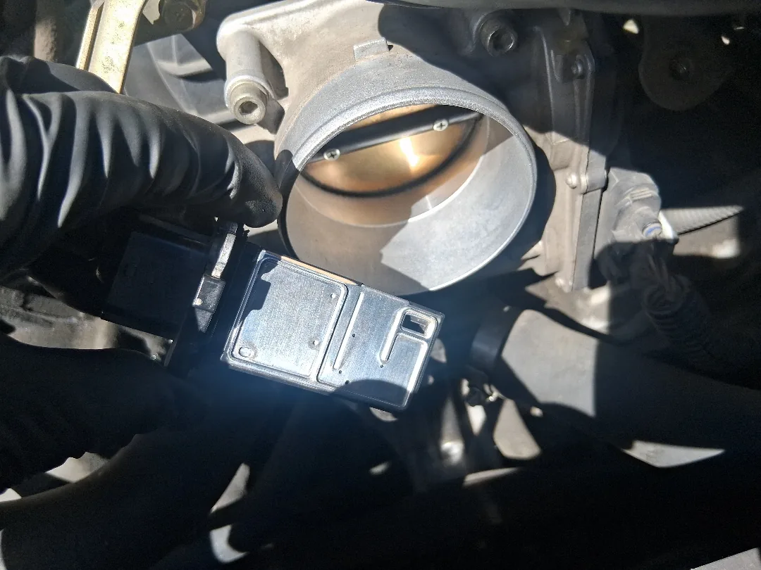 Throttle body removed from a Ford V8 for cleaning during the repair