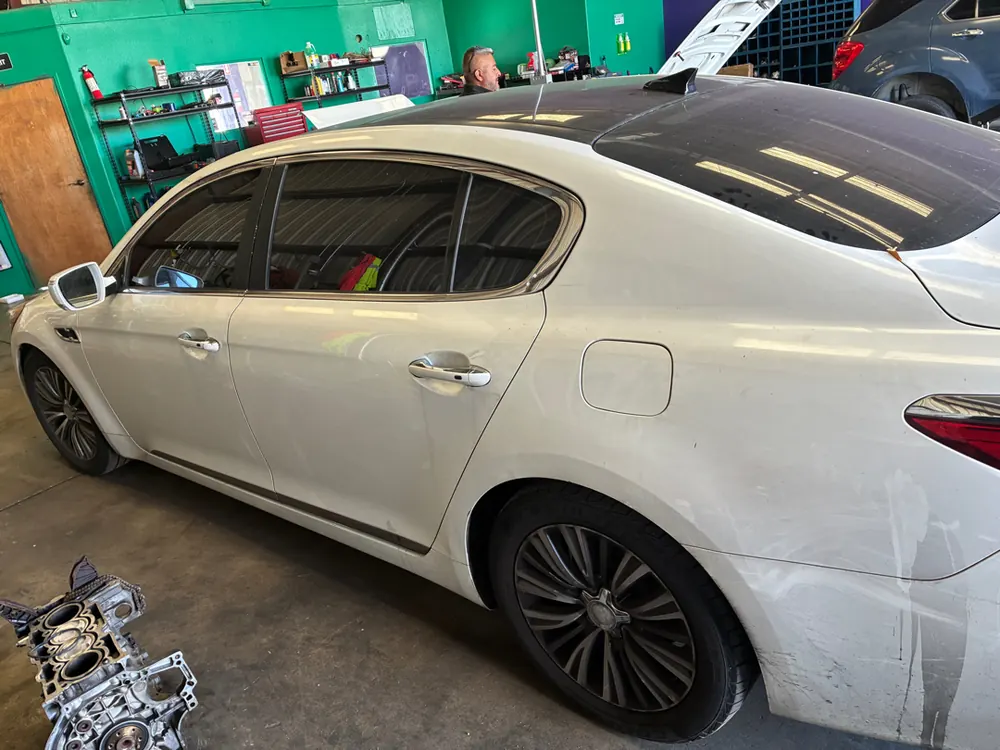 Kia K900 sedan in the shop bay for engine work for a Corona CA customer