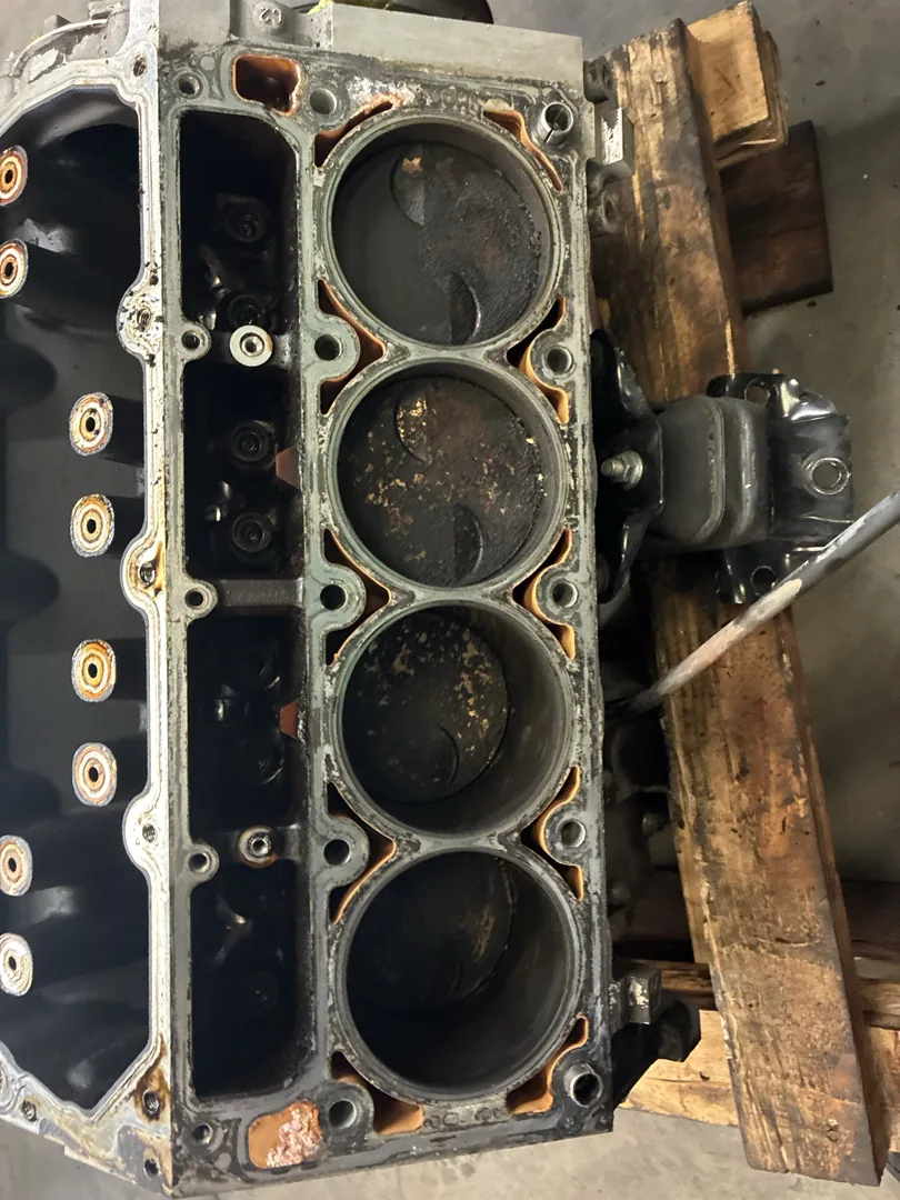 Stripped engine block on the bench with the cylinder bores exposed