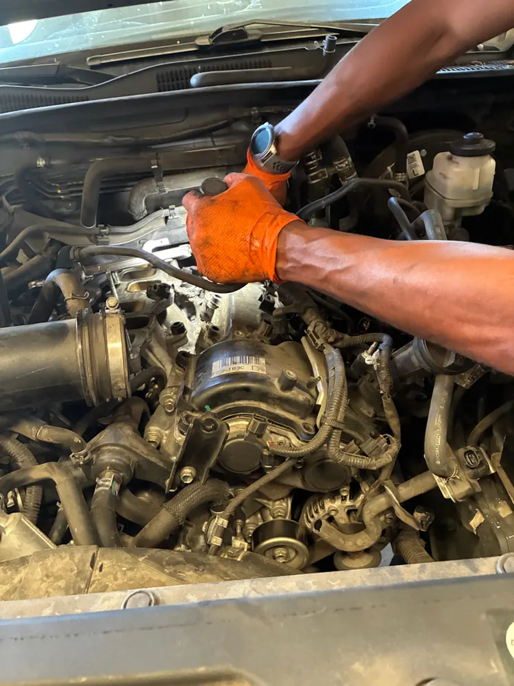Supercanic mechanic deep in an engine bay on a fuel injector job in Riverside CA