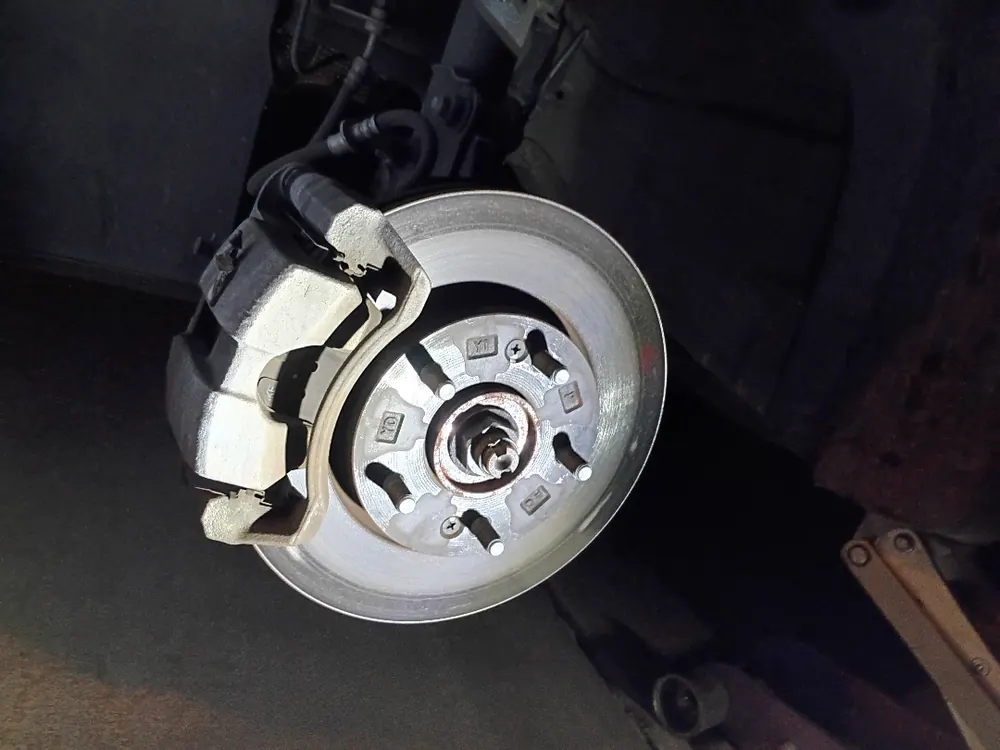 New brake pads installed on the caliper bracket during a Supercanic brake job