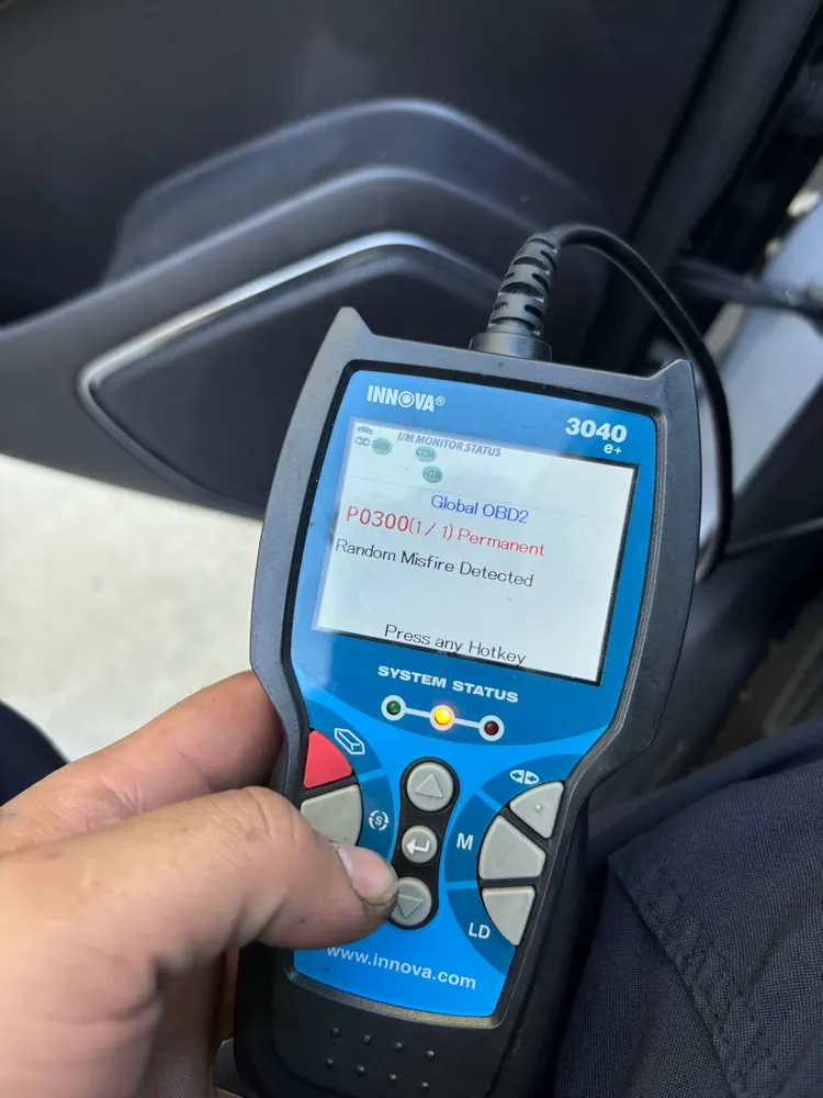 Hand-held scan tool showing a P0300 random misfire code during an engine diagnostic