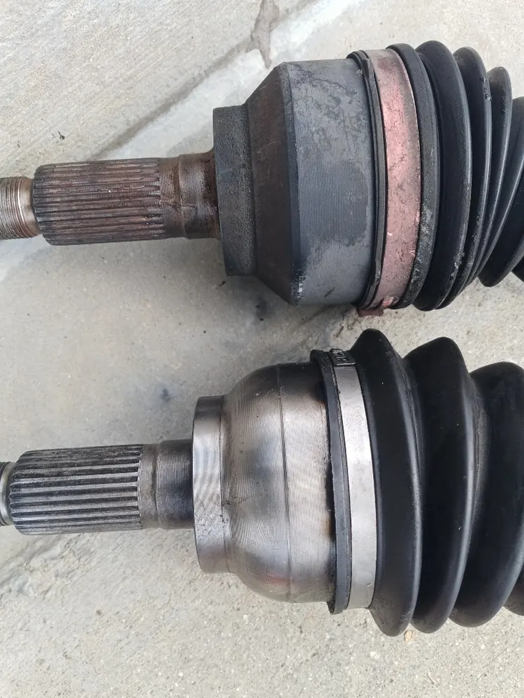 Old and new CV axles side by side during a front axle replacement in Hemet CA